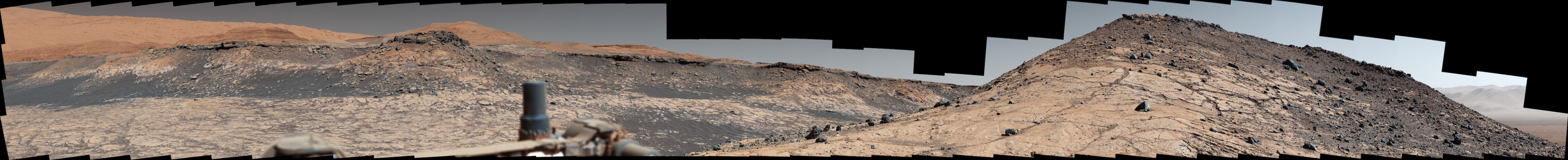 This wide panorama was taken by NASA's Curiosity Mars rover on Dec. 19, 2019, the 2,620th Martian day, or sol, of the mission. On the righthand foreground is Western Butte; the ridge with a crusty cap in the background is the Greenheugh pediment, which Curiosity ascended in March of 2020.