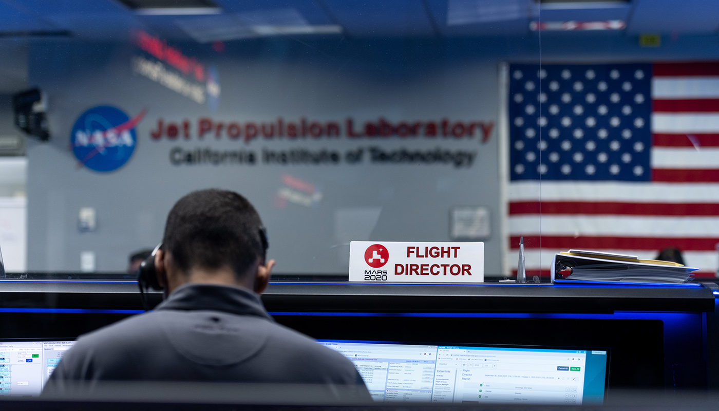 Flight director sign in mission control with American flag in background