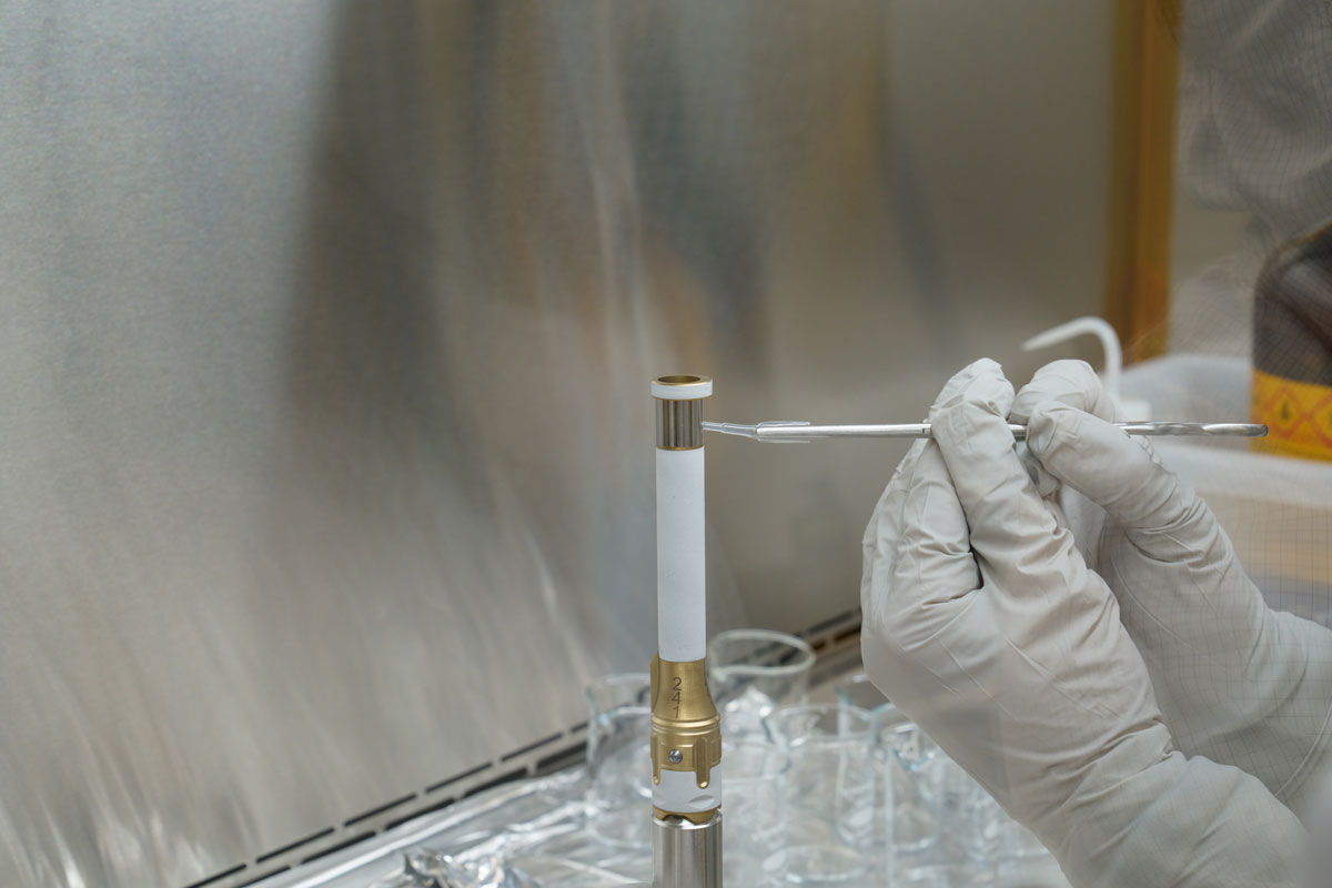 A technician working on the Mars 2020 mission takes a sample from the surface of sample tube 241 – to test for contamination.