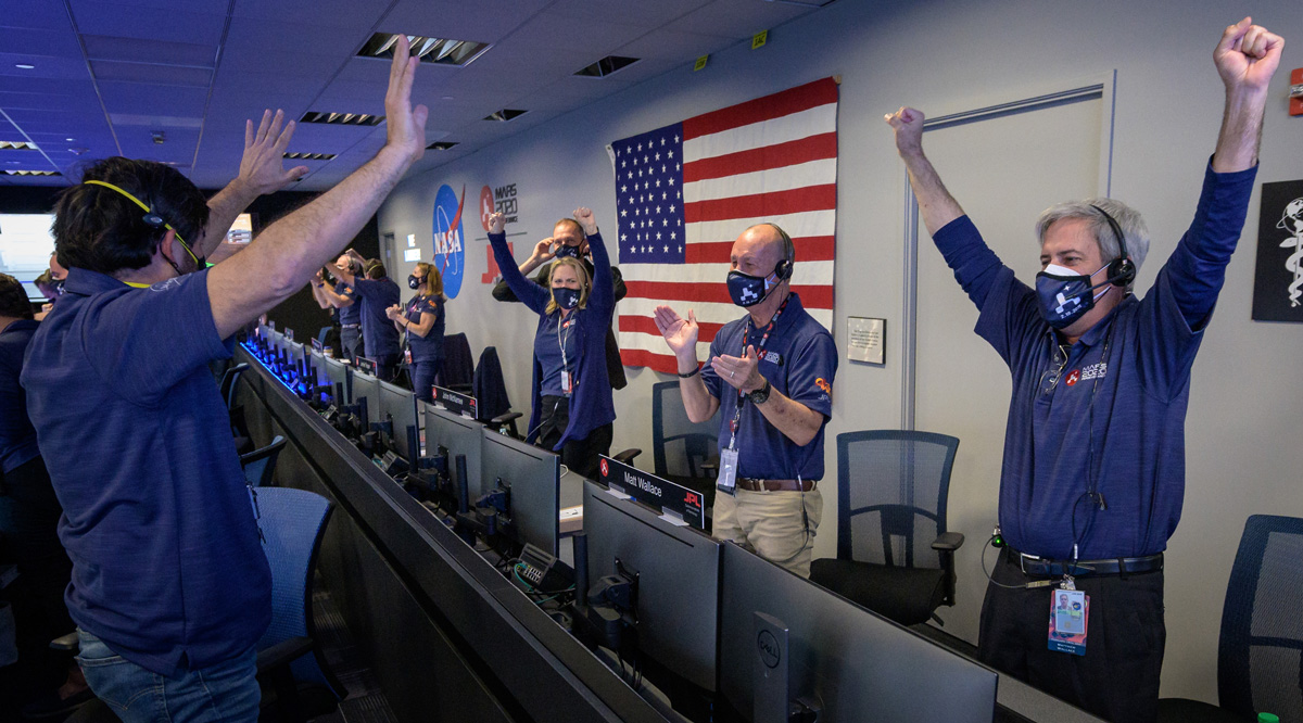 Members of NASA’s Perseverance rover team react as they hear Perseverance is safe on the ground
