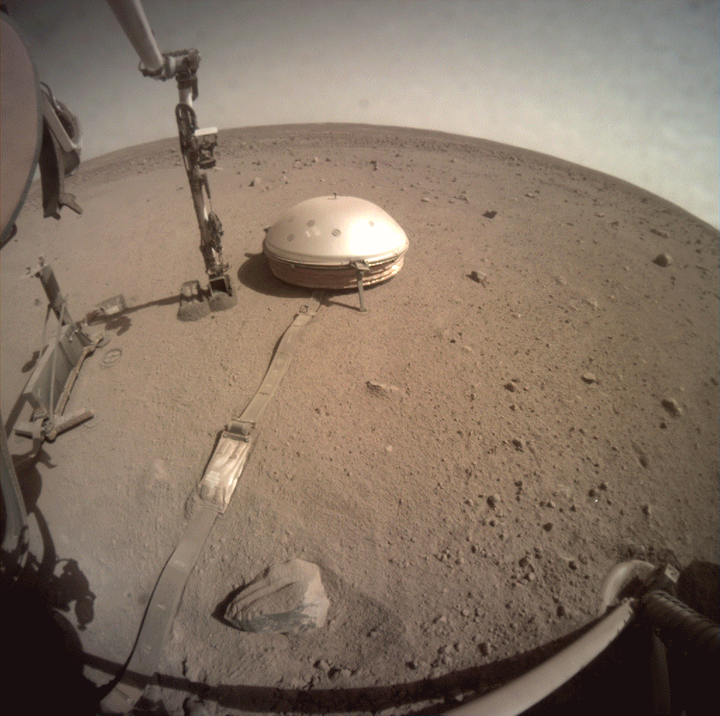 InSight lander used a scoop on its robotic arm to begin trickling soil over the cable connecting its seismometer to the spacecraft
