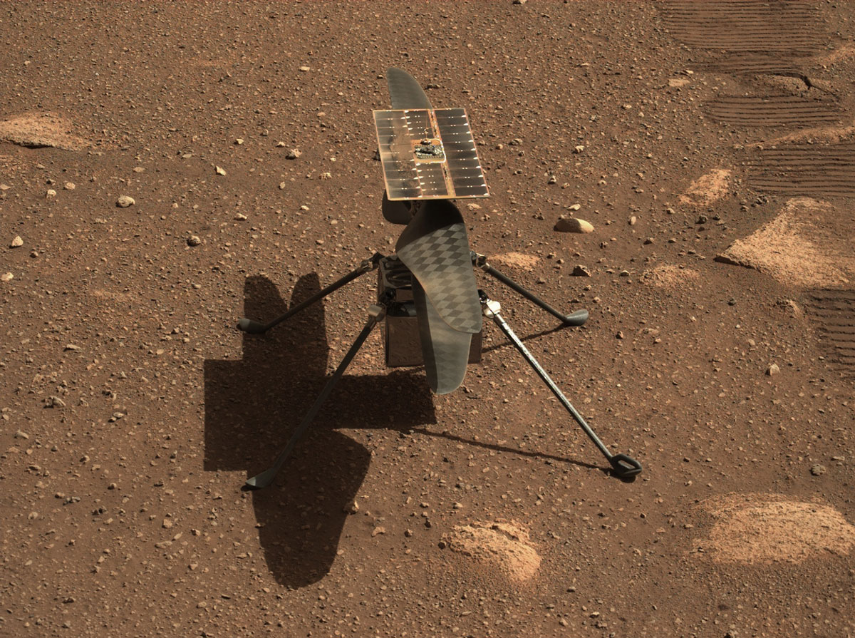A small helicopter sits on the surface of Mars