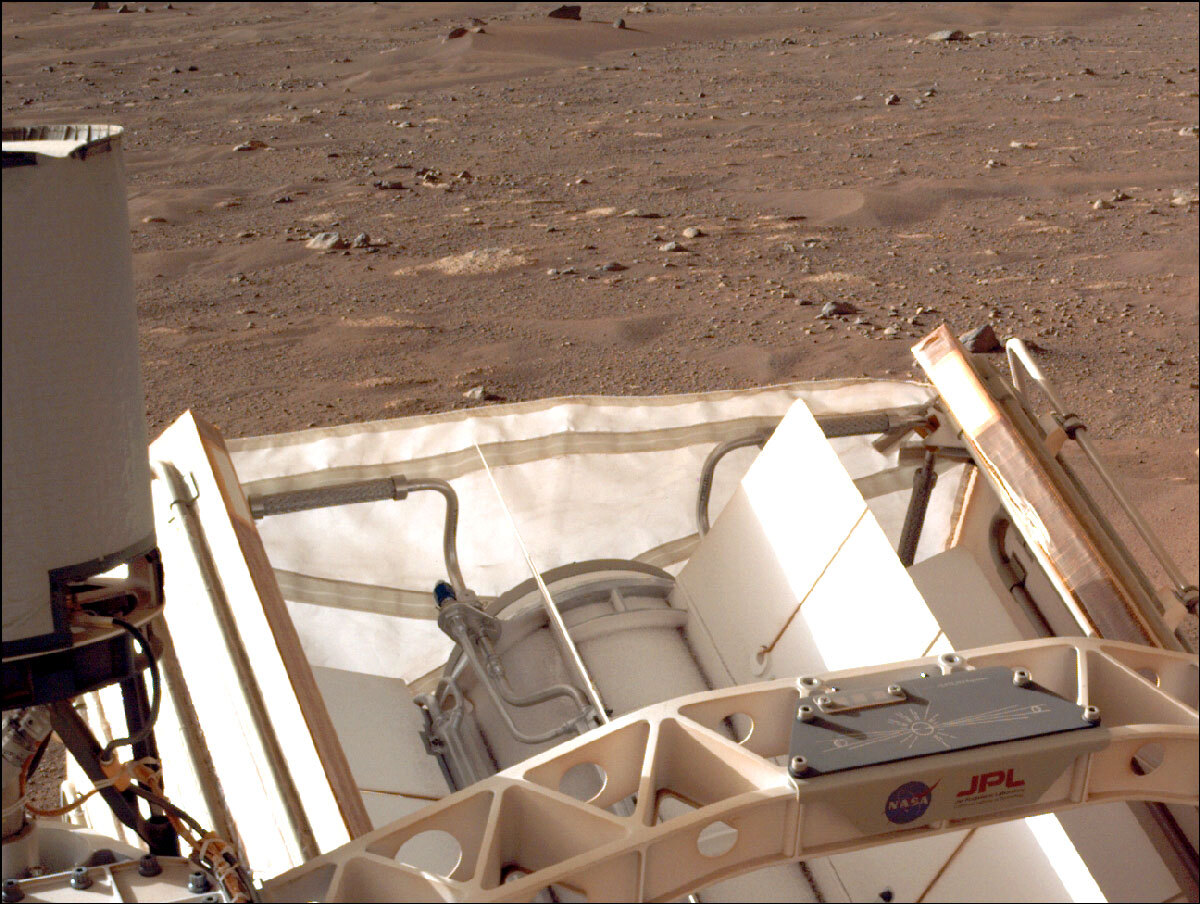 Close up image of Perseverance rover's deck shows a black plate with the three chips and a line drawing showing Mars and Earth with the Sun in the middle.