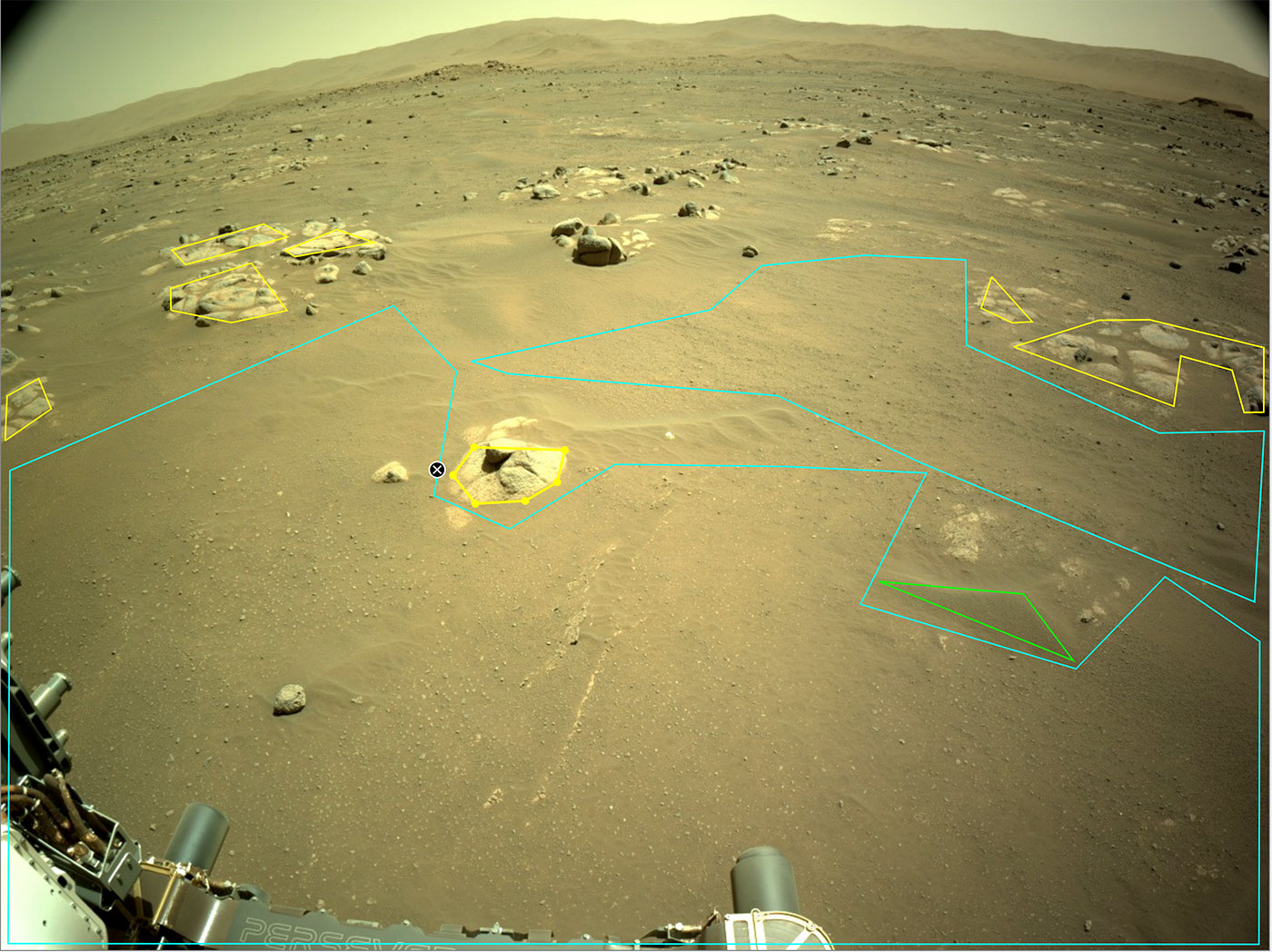 This is an image of the rocky, sandy surface of Mars with outlines of the artificial intelligence software on the image. The artificial intelligence software is outlinig particular rocks int the front view. Low hills are present in the horizon of the image.