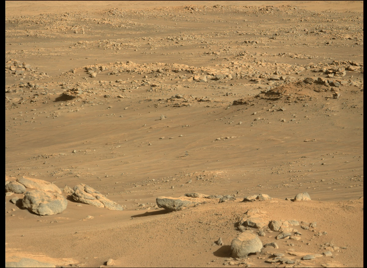 Ingenuity sits on a slightly inclined surface with about 6-degree tilt at the center of the frame, just north of the southern ridge of “Séíitah” geologic unit. The Perseverance rover’s Mastcam-Z instrument took this image on Dec. 1, 2021, when the rotorcraft was about 970 feet (295 meters) away.