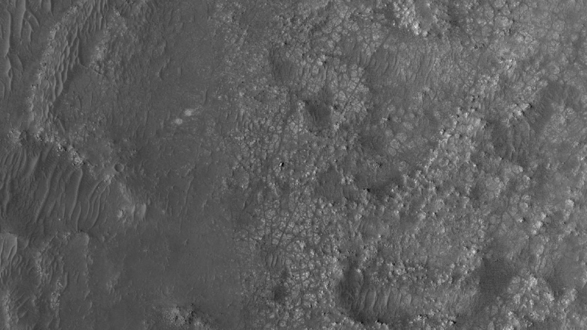 NASA’s Perseverance Mars rover and Ingenuity helicopter were spotted on the surface of the Red Planet in this black-and-white image captured Feb. 26, 2022, by the HiRISE camera aboard NASA’s Mars Reconnaissance Orbiter.