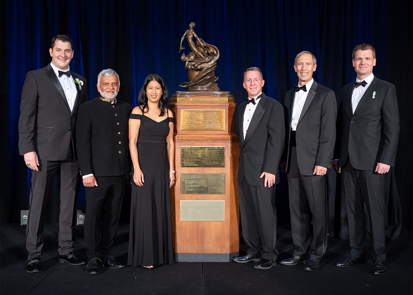 This image shows members of the Ingenuity Mars Helicopter team standing next to the NAA Collier Trophy on June 9, 2022.