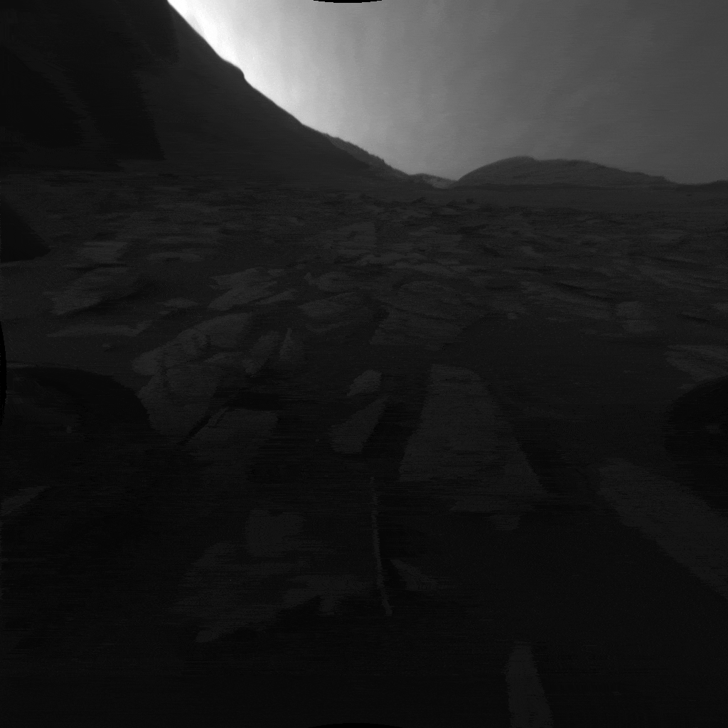 While stationary for two weeks during Mars solar conjunction in November 2023, NASA’s Curiosity rover used its front and rear black-and-white Hazcams to capture 12 hours of a Martian day. The rover’s shadow is visible on the surface in these images taken by the front Hazcam.