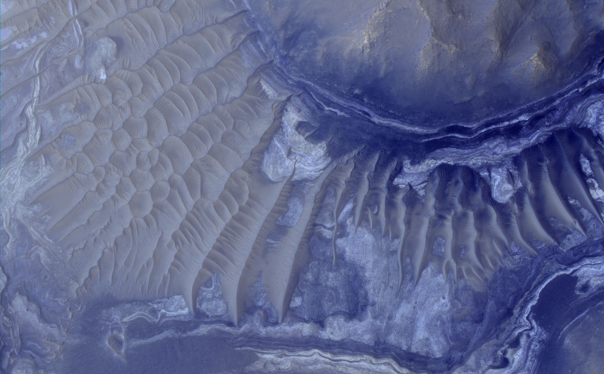 Layers in the lower portion of two neighboring buttes within the Noctis Labyrinthus formation on Mars are visible in this image from the High Resolution Imaging Science Experiment (HiRISE) camera on NASA's Mars Reconnaissance Orbiter. The view covers an area about 1 kilometer (0.6 mile) wide.