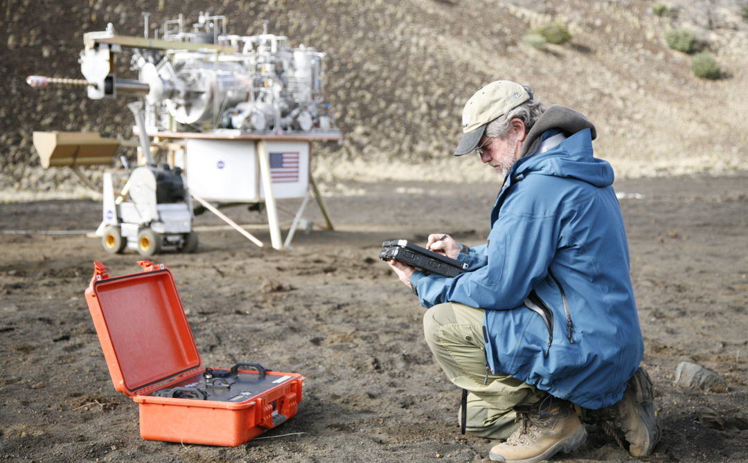 This image shows a miniaturized laboratory, in an orange case, in use during an expedition to the Mauna Kea volcano in Hawaii.