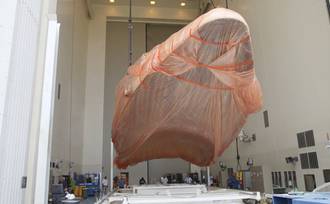Half of the Atlas V payload fairing for NASA's Mars Science Laboratory (MSL) mission, encased in plastic, is lifted from its transportation pallet in the airlock of the Payload Hazardous Servicing Facility at NASA's Kennedy Space Center in Florida.