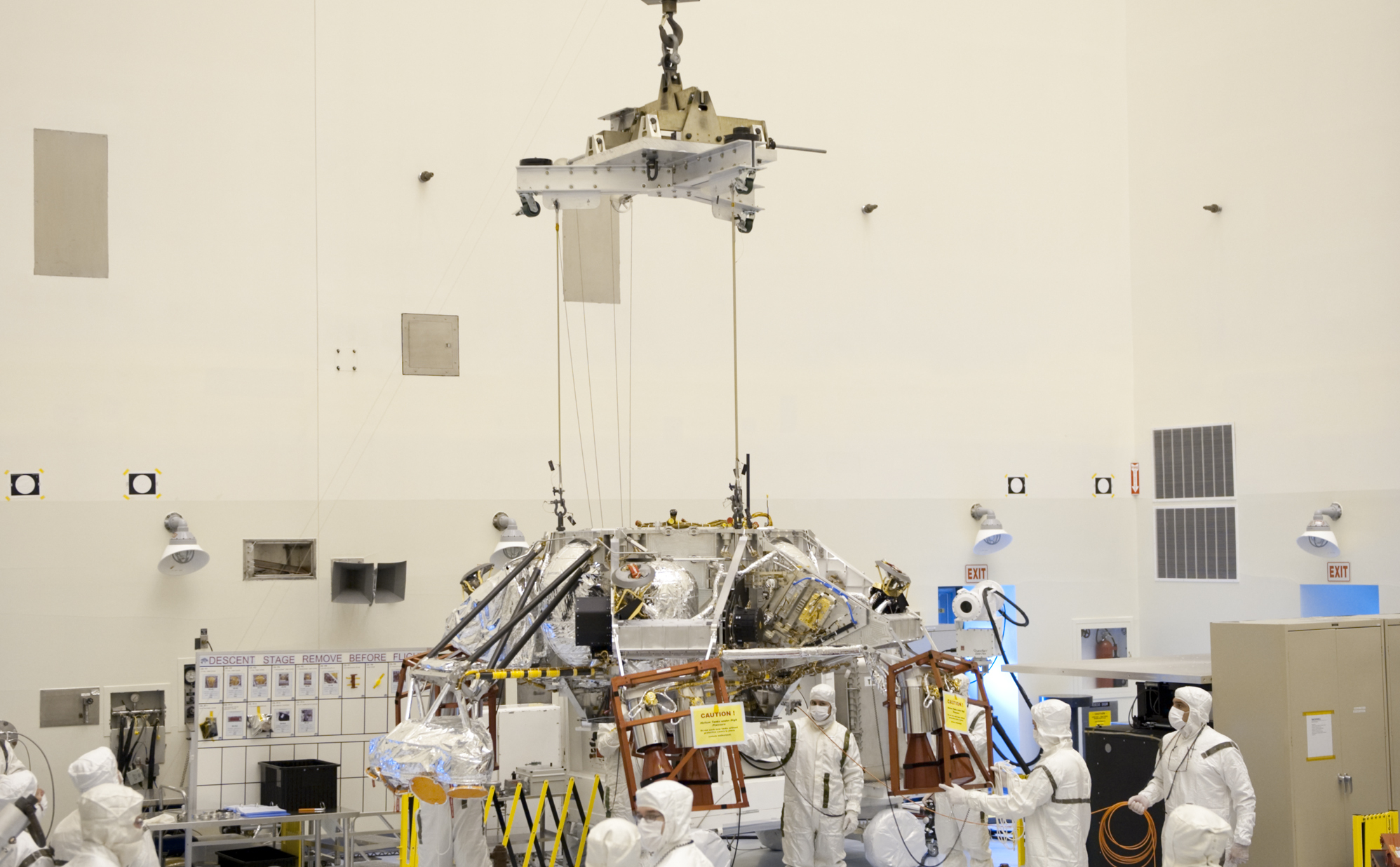 Technicians, at the Payload Hazardous Servicing Facility at NASA's Kennedy Space Center in Florida, use an overhead crane to move a rocket-powered descent stage for integration with NASA's Mars Science Laboratory (MSL) rover, known as Curiosity.
