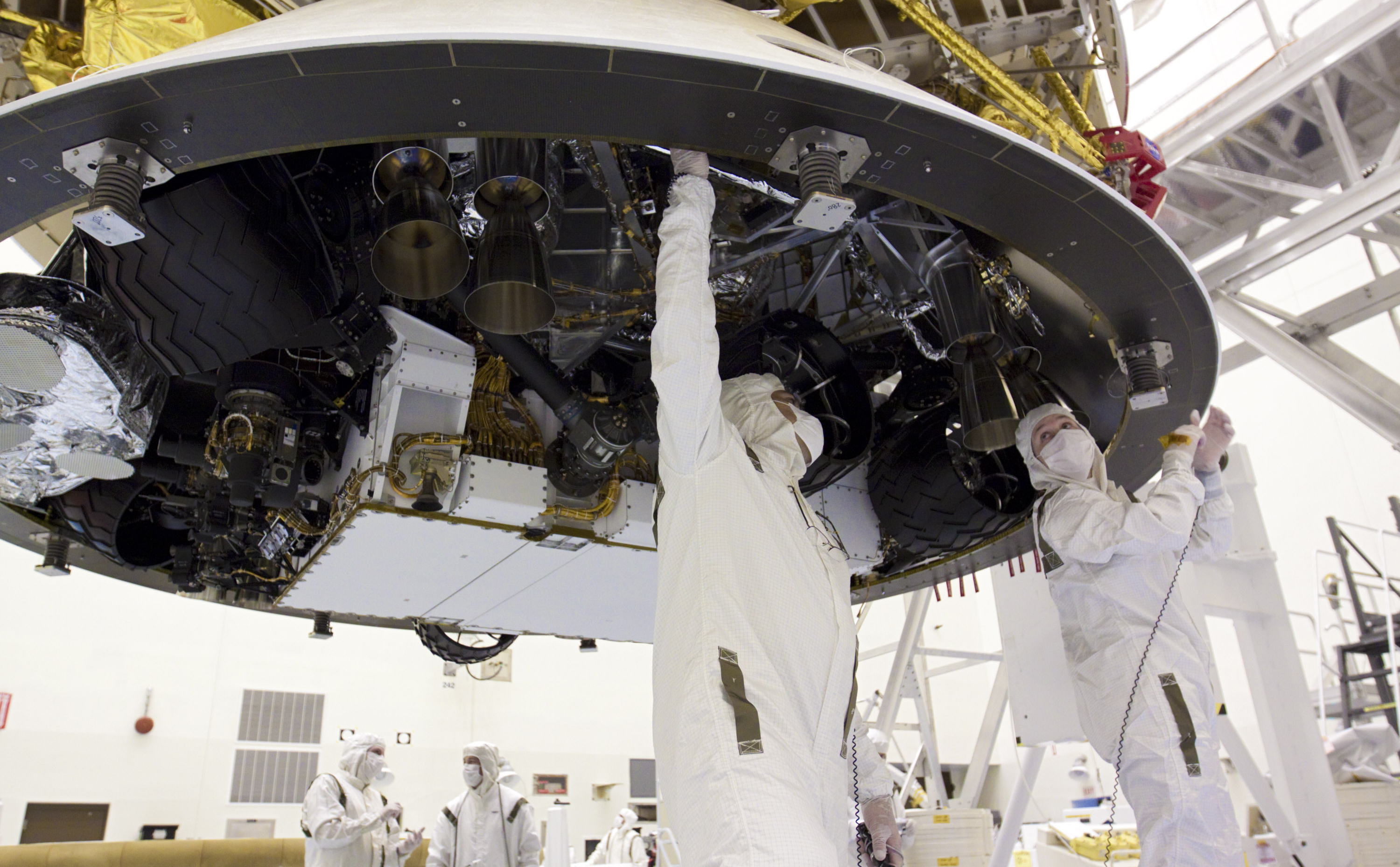 In the Payload Hazardous Servicing Facility at NASA's Kennedy Space Center in Florida, technicians work beneath NASA's Mars Science Laboratory (MSL) mission aeroshell, (containing the compact car-sized rover Curiosity), which has been mated to the cruise stage.
