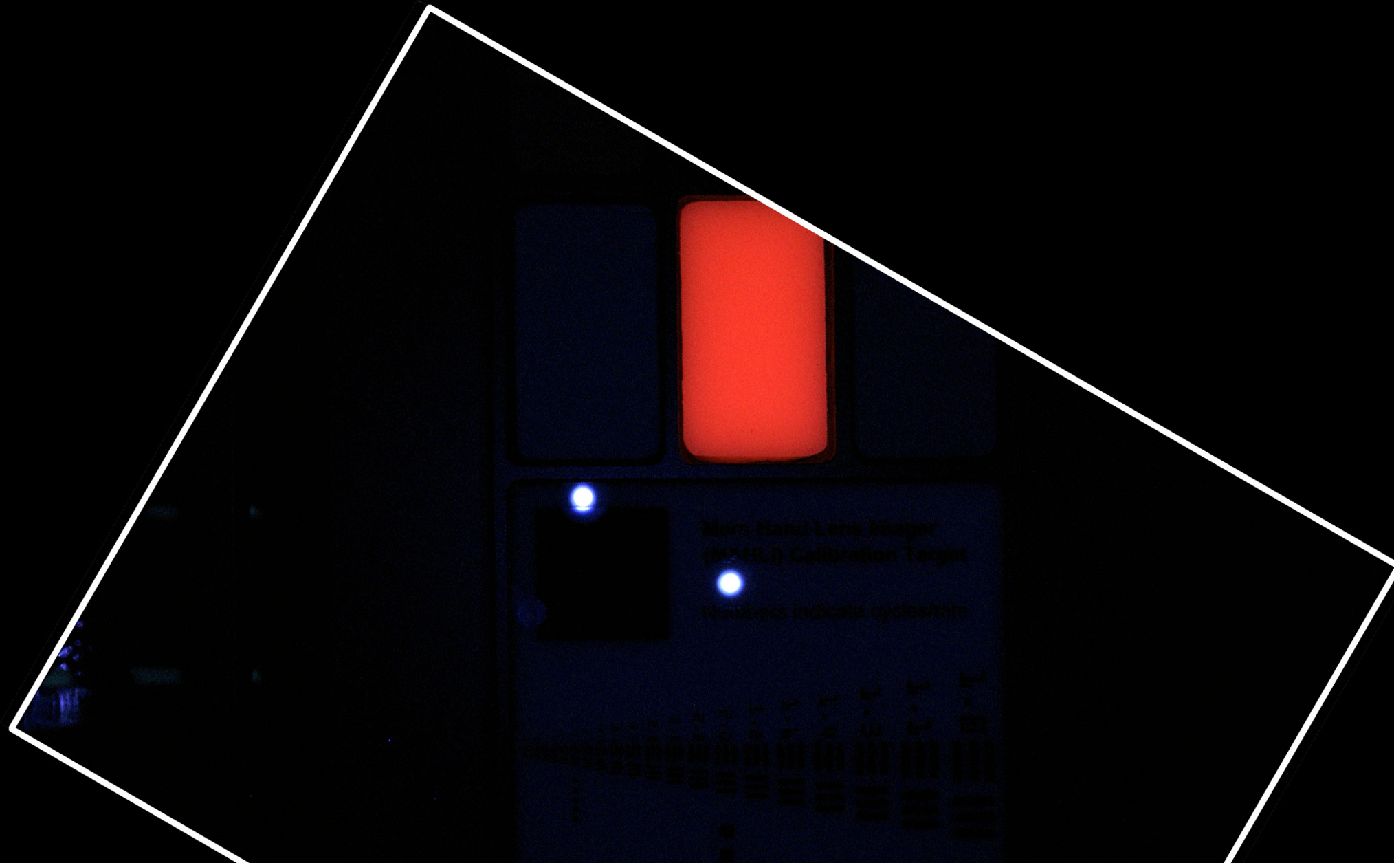 During pre-flight testing in March 2011, the Mars Hand Lens Imager (MAHLI) camera on NASA's Mars rover Curiosity took this image of the MAHLI calibration target under illumination from MAHLI's two ultraviolet LEDs (light emitting diodes).