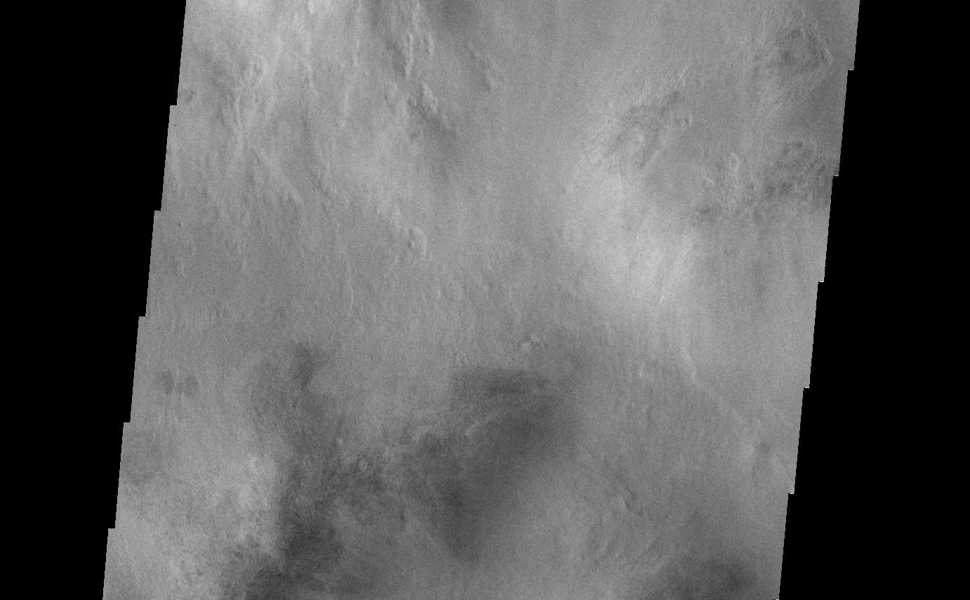 The floor of this unnamed crater in Aonia Terra has been filled with multiple layers of material.