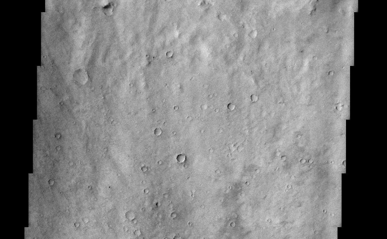This THEMIS visible image shows a close-up view of the ridged plains in Hesperia Planum. This region is the classic locality for martian surfaces that formed in the "middle ages" of martian history. The absolute age of these surfaces is not well known. However, using the abundance of impact craters, it is possible to determine that the Hesperian plains are younger than the ancient cratered terrains that dominate the southern hemisphere, and are older than low-lying plains of the northern hemisphere. In this image it is possible to see that this surface has a large number of 1-3 km diameter craters, indicating that this region is indeed very old and has subjected to a long period of bombardment. A large (80 km diameter) crater occurs just to the north (above) this image. The material that was thrown out onto the surface when the crater was formed ("crater ejecta") can be seen at the top of the THEMIS image. This ejecta material has been heavily eroded and modified since its formation, but there are hints of lobate flow features within the ejecta. Lobate ejecta deposits are thought to indicate that ice was present beneath the surface when the crater was formed, leading to these unusual lobate features. Many of the Hesperian plains are characterized by ridged surfaces. These ridges can be easily seen in the MOLA context image, and several can be seen cutting across the lower portion of the THEMIS image. These "wrinkle" ridges are thought to be the result of compression (squeezing) of the lavas that form these plains.