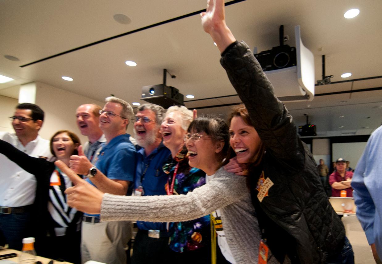 Members of the Curiosity science team jump out of their seats and cheer when they hear that the Curiosity rover has successfully landed on the Martian surface.