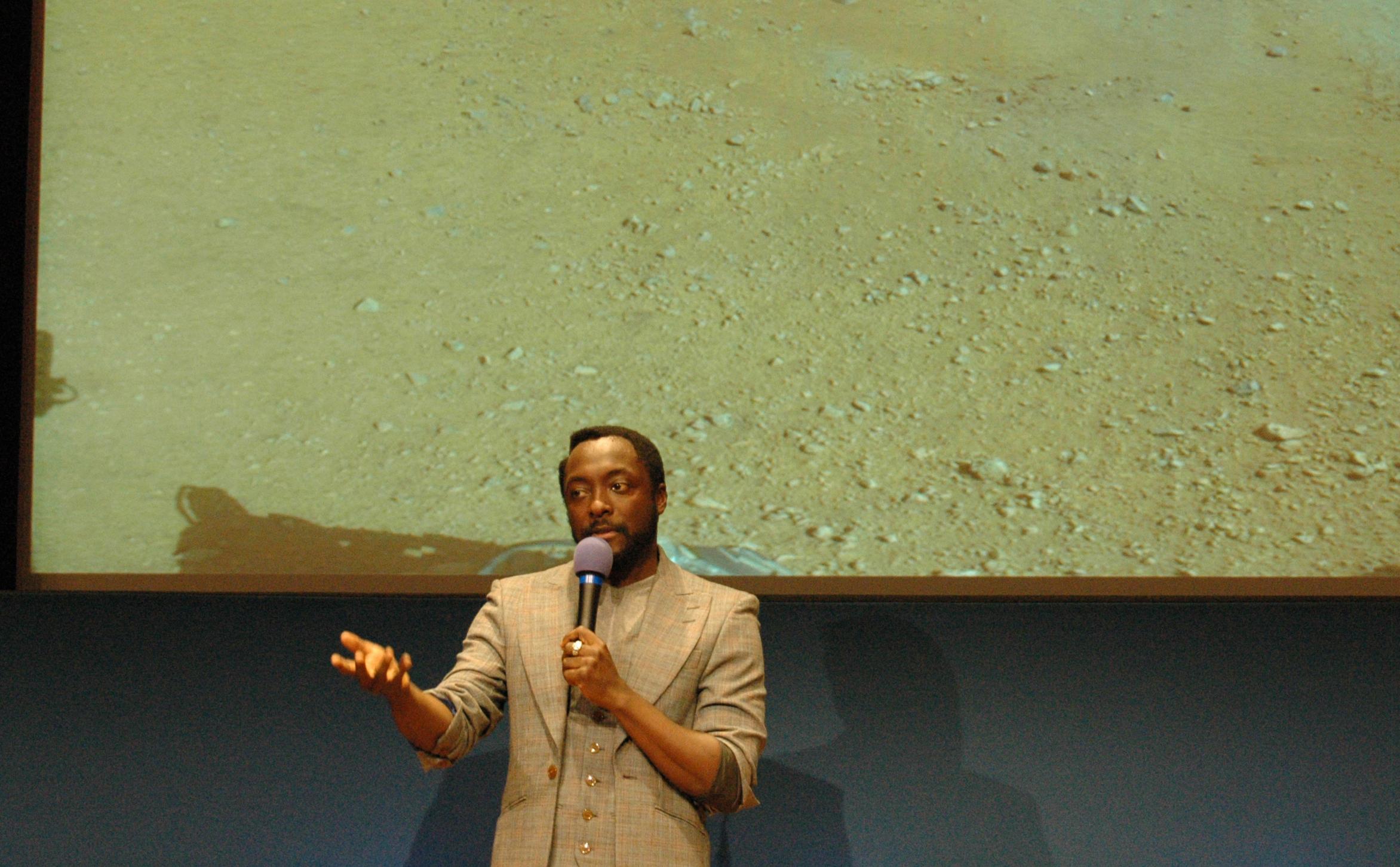 Musician will.i.am addresses a crowd of students at JPL during an event celebrating the first time in history that a recorded song has been beamed back to Earth from another planet.