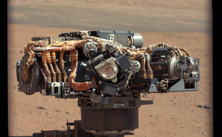 This image shows the Mars Hand Lens Imager (MAHLI) on NASA's Curiosity rover, with the Martian landscape in the background.
