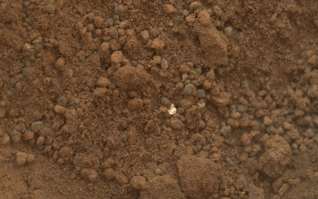 This image shows part of the small pit or bite created when NASA's Mars rover Curiosity collected its second scoop of Martian soil at a sandy patch called "Rocknest."