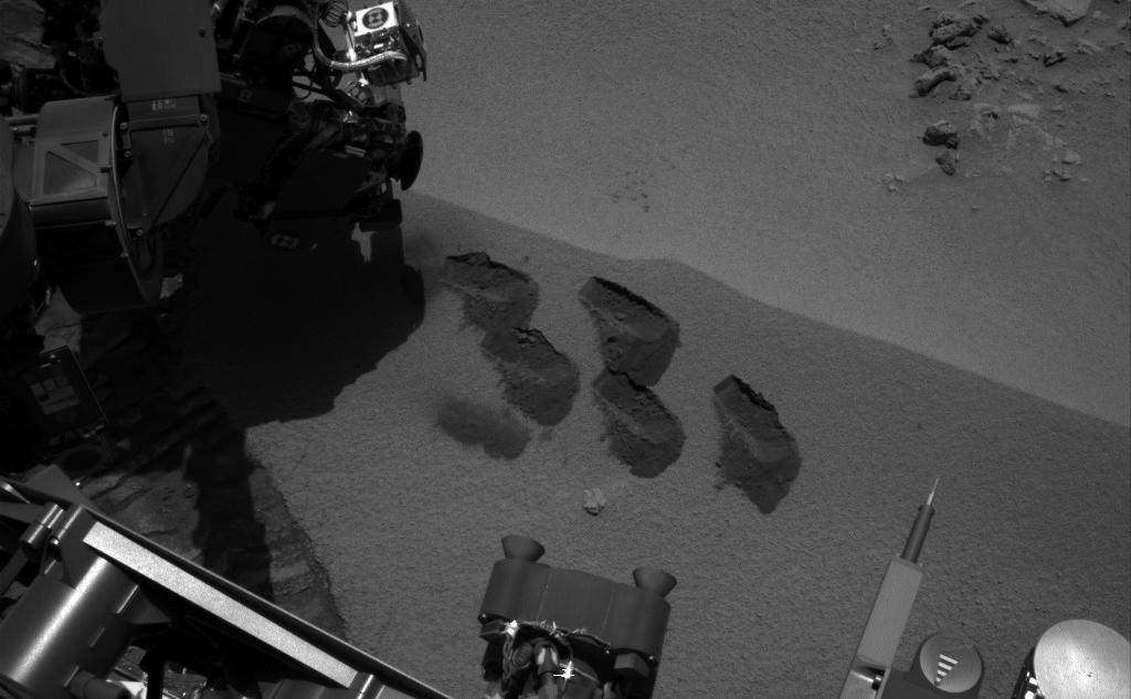 NASA's Mars rover Curiosity used a mechanism on its robotic arm to dig up five scoopfuls of material from a patch of dusty sand called "Rocknest," producing the five bite-mark pits visible in this image from the rover's left Navigation Camera (Navcam).