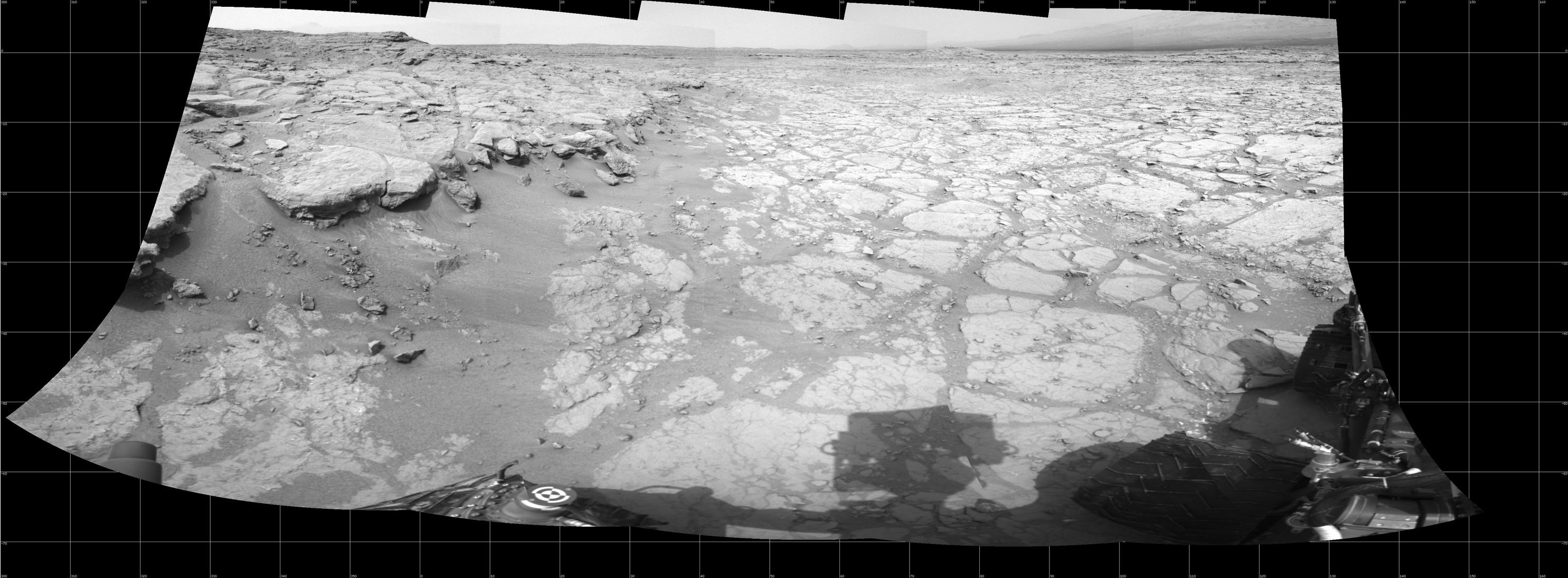 In a shallow depression called "Yellowknife Bay," the NASA Mars rover Curiosity drove to an edge of the feature during the 130th Martian day, or sol, of the mission (Dec. 17, 2012) and used its Navigation Camera to record this view of the ledge at the margin and a view across the "bay."