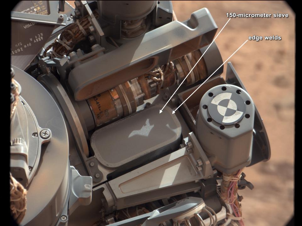 This image shows the location of the 150-micrometer sieve screen on NASA's Mars rover Curiosity, a device used to remove larger particles from samples before delivery to science instruments.