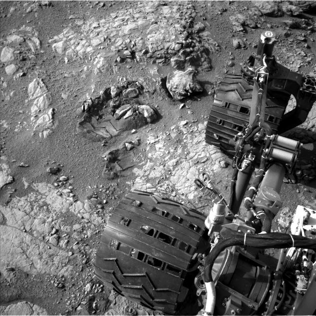 This view of Curiosity's left-front and left-center wheels and of marks made by wheels on the ground in the "Yellowknife Bay" area comes from one of six cameras used on Mars for the first time more than six months after the rover landed.