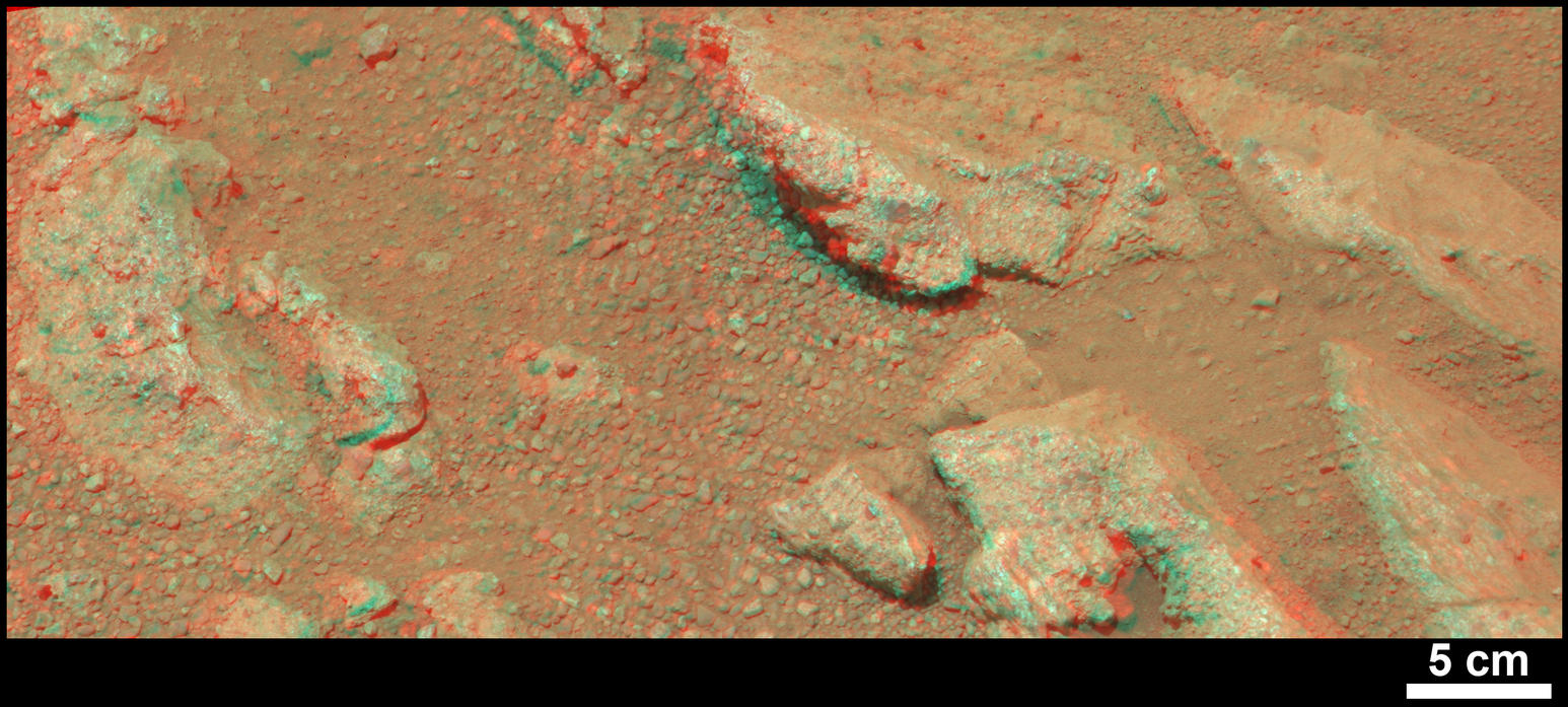 This stereo view from NASA's Mars rover Curiosity shows a rock called "Link," which bears rounded pebbles that provide evidence about vigorous flow of water in a stream on ancient Mars.