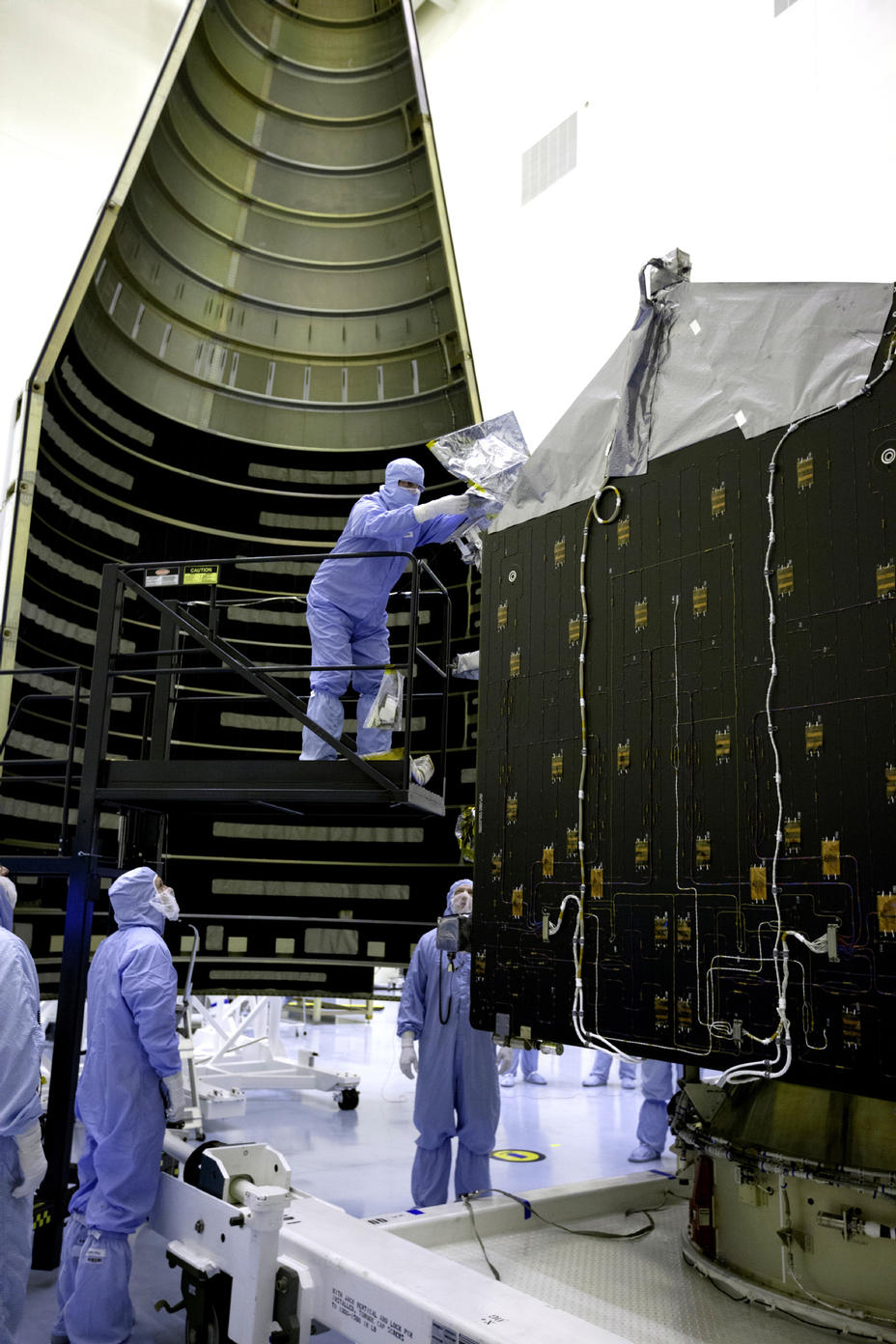 Inside the Payload Hazardous Servicing Facility at NASA's Kennedy Space Center in Florida, engineers and technicians prepare the Mars Atmosphere and Volatile Evolution, or MAVEN, spacecraft for encapsulation inside its payload fairing.