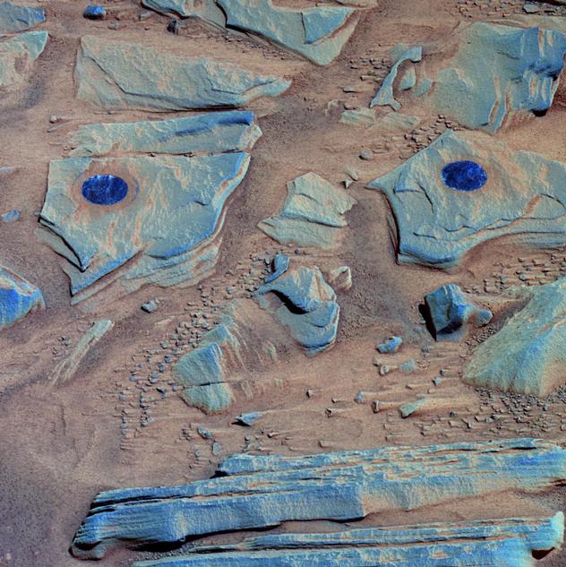 Spirit acquired this false-color image after using the rock abrasion tool to brush the surfaces of rock targets informally named "Stars" (left) and "Crawfords" (right). Small streaks of dust extend for several centimeters behind the small rock chips and pebbles in the dusty, red soils. Because the rover was looking southwest when this image was taken, the wind streaks indicate that the dominant wind direction was from the southeast.