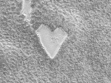 The Mars Global Surveyor (MGS) Mars Orbiter Camera (MOC) captured this unique view of a bright, heart-shaped mesa in the south polar region on November 26, 1999.  The presence of this mesa indicates that the darker, rough terrain that surrounds it was once covered by a layer of the bright material.