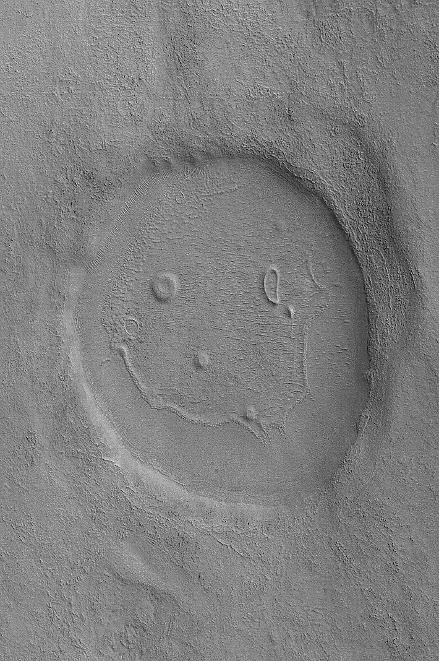 This picture of a crater resembling a "happy face" was taken in January 2008, by the Mars Reconnaissance Orbiter's Context Camera. The unnamed crater is almost 2 miles (about 3 kilometers) across.