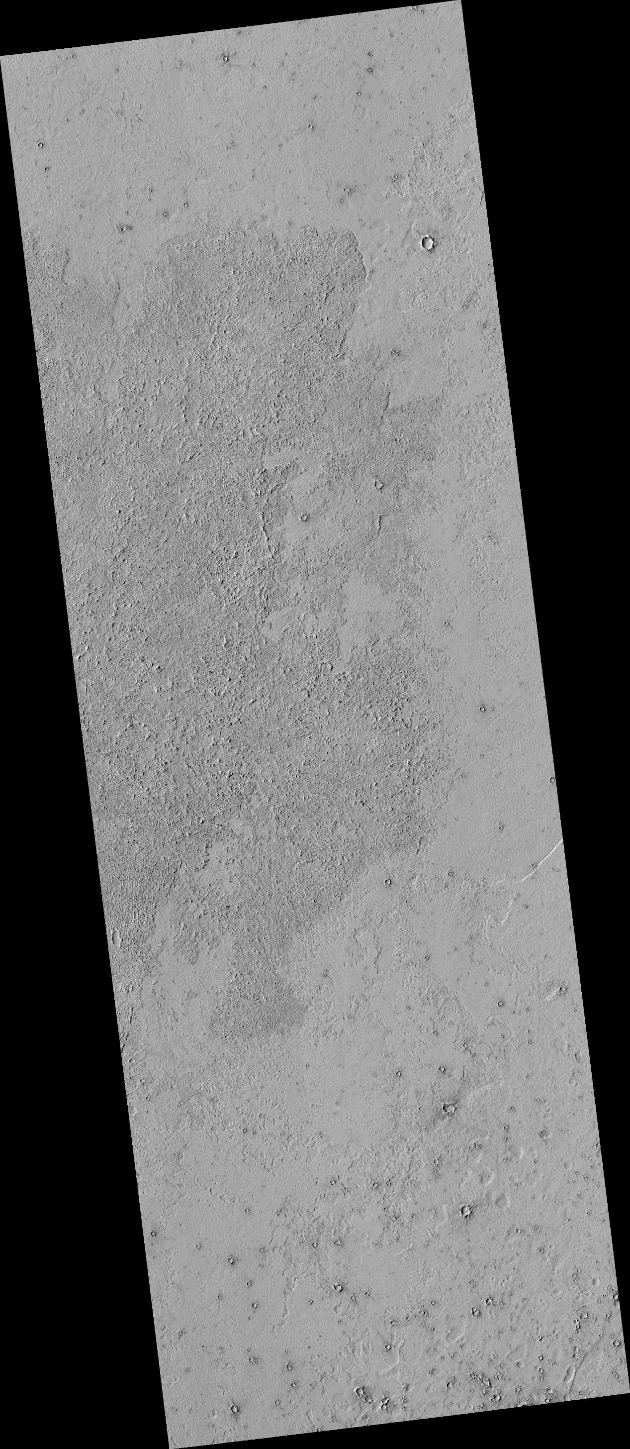 This image shows details of the lava covered plains near the equator of Mars. The darker looking area has a rough lava surface with all the shadows giving the region a darker appearance.