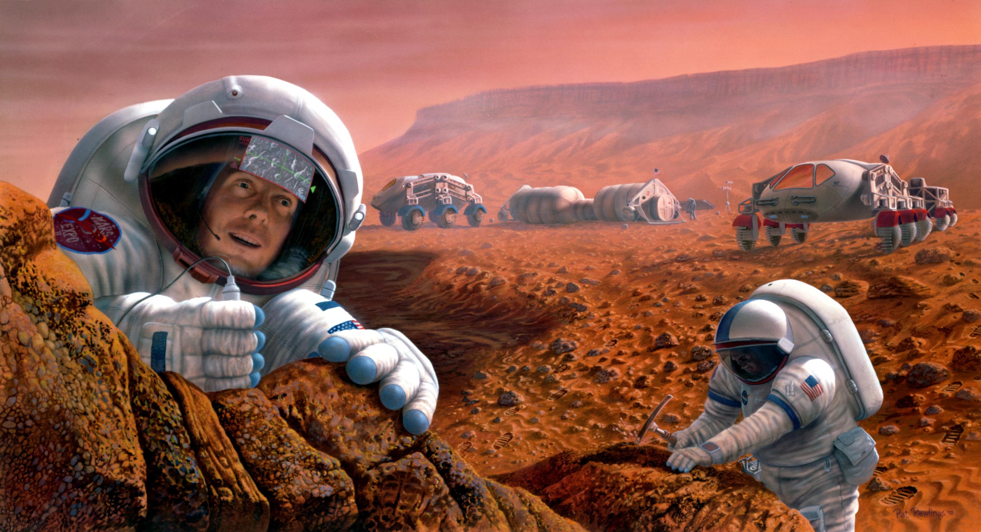 Two astronauts study a rock formation on Mars.  One is seen chipping away at a rock.  Two vehicles and an outpost are seen in the background.