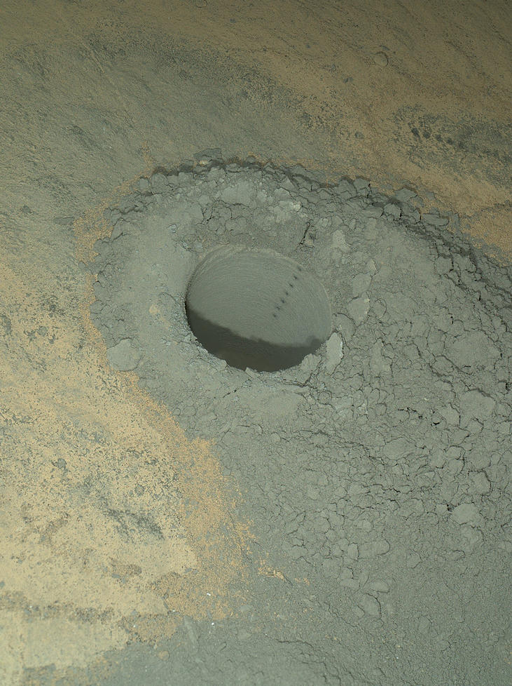 The Mars Hand Lens Imager on NASA's Curiosity Mars rover provided this nighttime view of a hole produced by the rover's drill and, inside the hole, a line of scars produced by the rover's rock-zapping laser.  The camera used its own white-light LEDs to illuminate the scene on May 13, 2014.