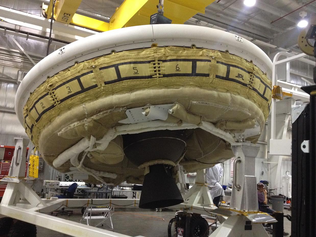 A saucer-shaped test vehicle holding equipment for landing large payloads on Mars is shown in the Missile Assembly Building at the US Navy's Pacific Missile Range Facility in Kaua'i, Hawaii.