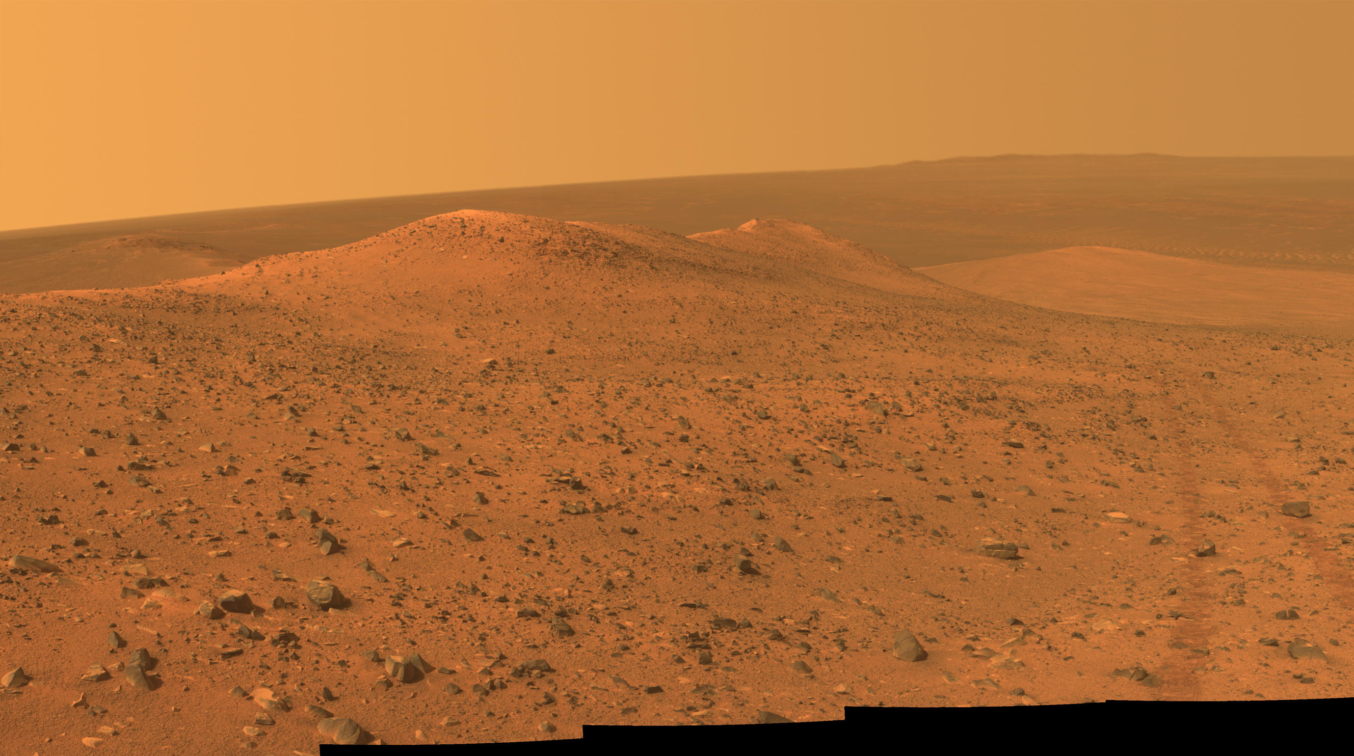 This vista from NASA's Mars Exploration Rover Opportunity shows Wdowiak Ridge, from left foreground to center, as part of a northward look with the rover's tracks visible at right.