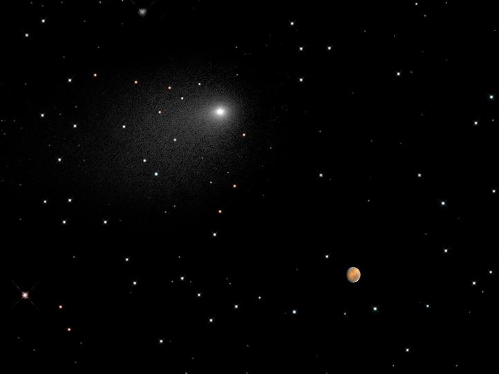 This image shows a star field with Mars as a small orange ball on the right and above it a bright comet in white with a tail.