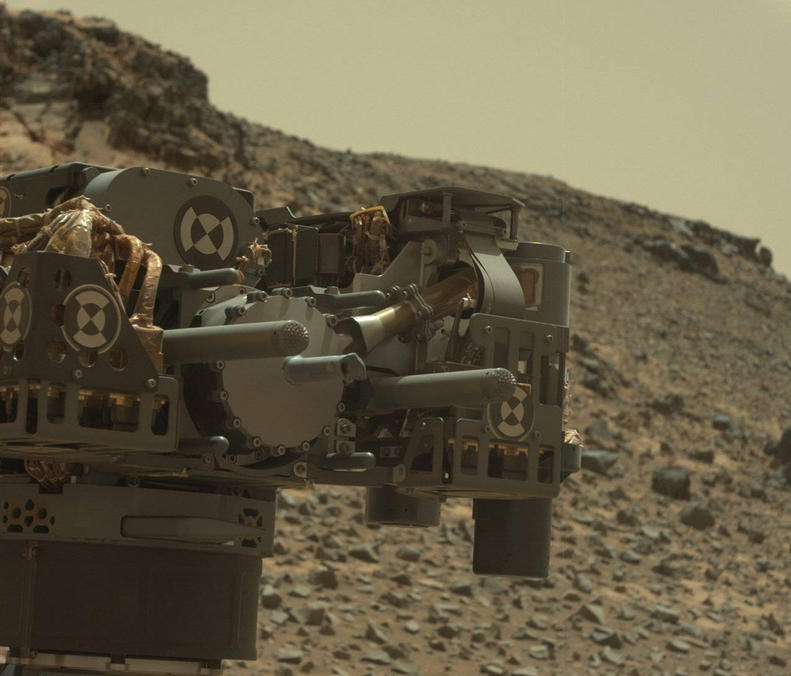 This raw-color view from Curiosity's Mastcam shows the rover's drill just after finishing a drilling operation at "Telegraph Peak" on Feb. 24, 2015. Three days later, a fault-protection action by the rover halted a process of transferring sample powder that was collected during this drilling.