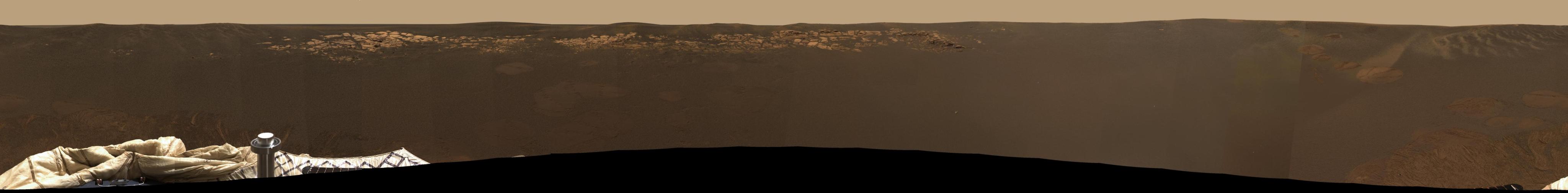 This expansive view of the martian real estate surrounding the Mars Exploration Rover Opportunity is the first 360 degree, high-resolution color image taken by the rover's panoramic camera.