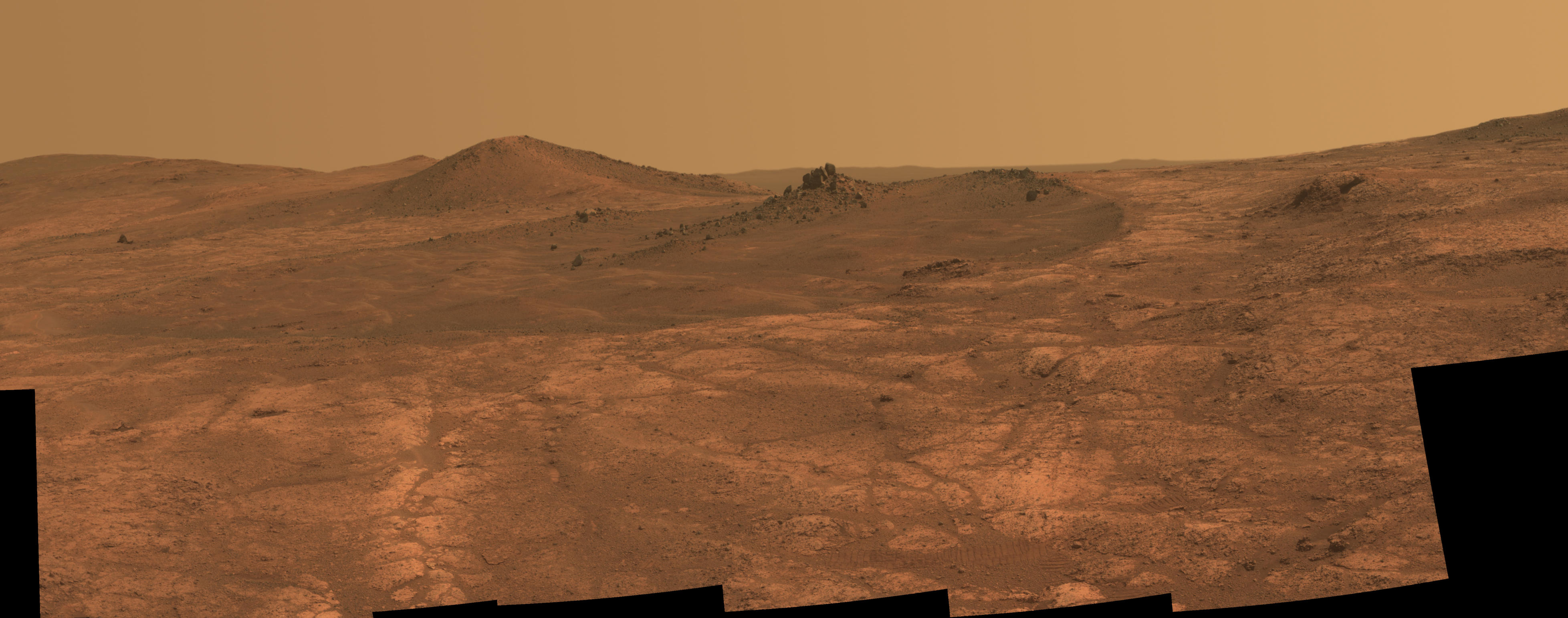 An elongated crater called "Spirit of St. Louis," with a rock spire in it, dominates a recent scene from the panoramic camera (Pancam) on NASA's Mars Exploration Rover Opportunity.