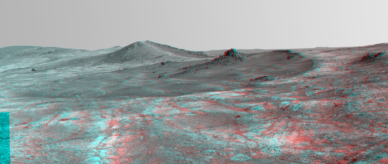 An elongated crater called "Spirit of St. Louis," with a rock spire in it, dominates this stereo view from NASA's Mars Exploration Rover Opportunity.