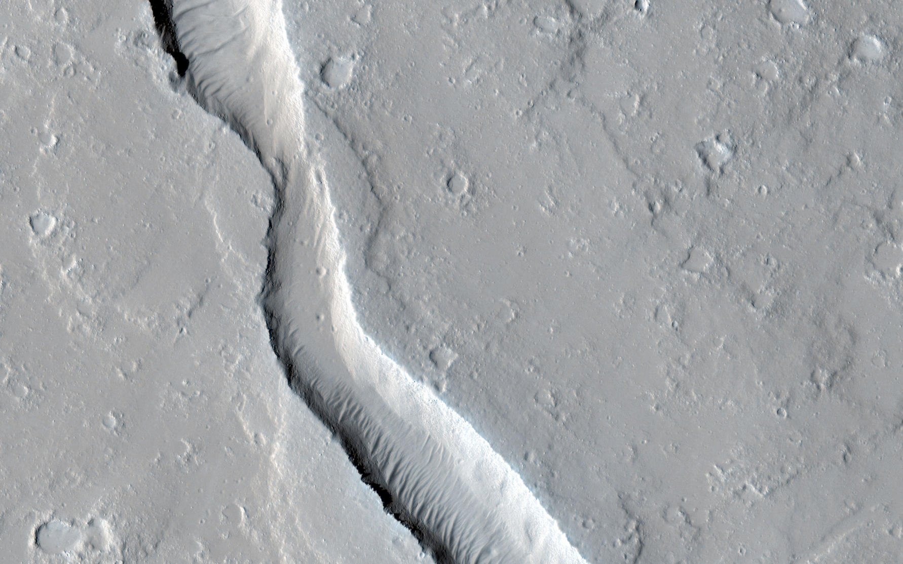 This image shows a lava channel, which lies just to the east of the largest volcano in the solar system: Olympus Mons.