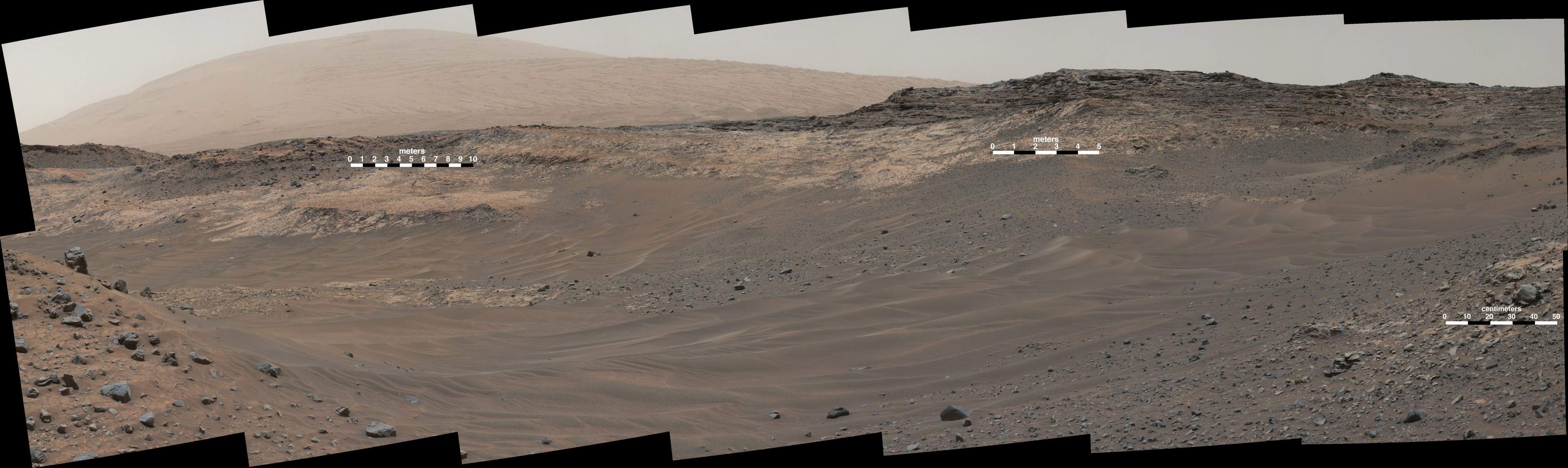 This May 10, 2015, view from Curiosity's Mastcam shows terrain judged difficult for traversing between the rover and an outcrop in the middle distance where a pale rock unit meets a darker rock unit above it. The rover team decided not to approach this outcrop and identified an alternative.