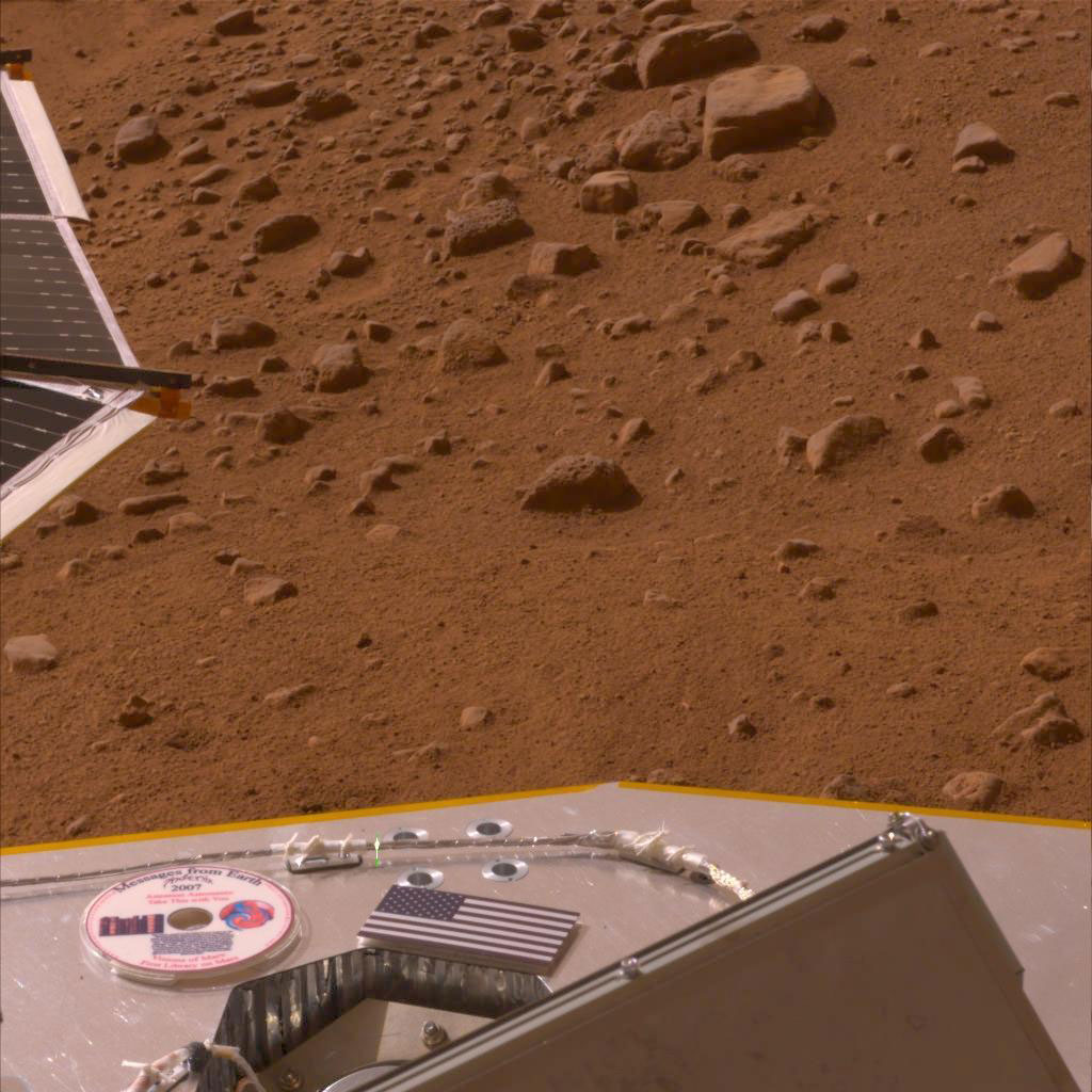This image, released on America's Memorial Day, May 26, 2008, shows the American flag and a mini-DVD on the Phoenix's deck, which is about 3 feet above the Martian surface.
