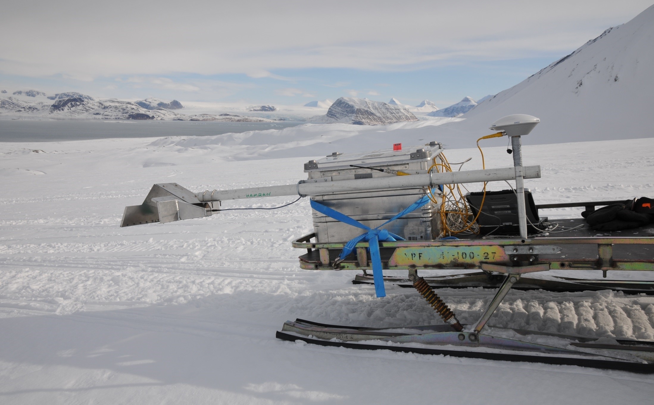 Photograph showing the prototype RIMFAX antenna attached to a snowmobile during tests in Svalbard, Norway.