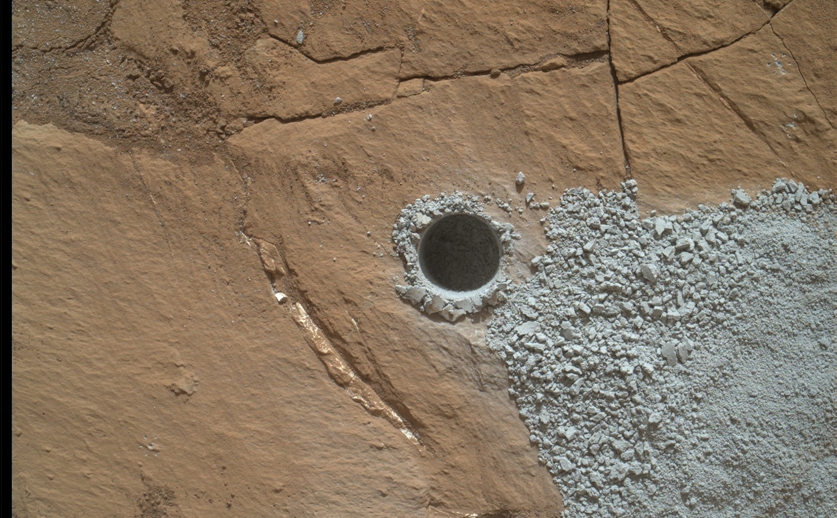 NASA's Curiosity Mars Rover drilled this hole to collect sample material from a rock target called "Buckskin" on July 30, 2015, about a week prior to the third anniversary of the rover's landing on Mars. The diameter is slightly smaller than a U.S. dime.
