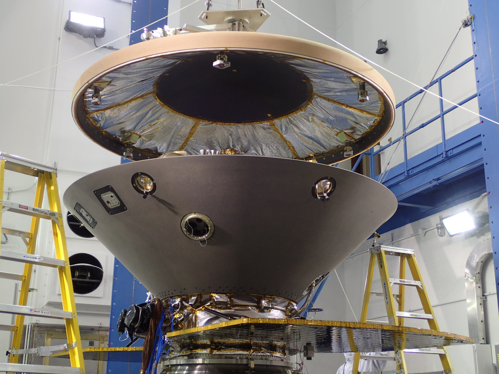 The heat shield is suspended above the rest of the InSight spacecraft in this image taken July 13, 2015, in a spacecraft assembly clean room at Lockheed Martin Space Systems, Denver.