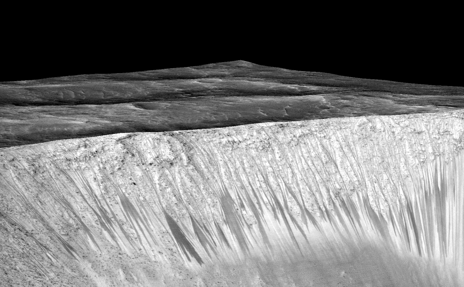 Dark narrow streaks, called "recurring slope lineae," emanate from the walls of Garni Crater on Mars, in this view constructed from observations by the High Resolution Imaging Science Experiment (HiRISE) camera on NASA's Mars Reconnaissance Orbiter.